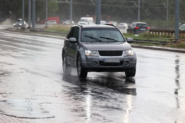 Auto sobre asfalto mojado ilustrando el riesgo de aquaplaning con lluvia