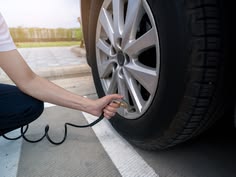 Manos revisando la presión para cuidar los neumáticos de un auto