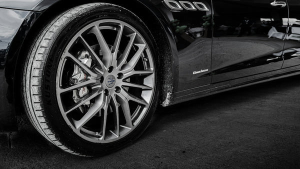 Rueda de un auto negro con llanta de rayos finos