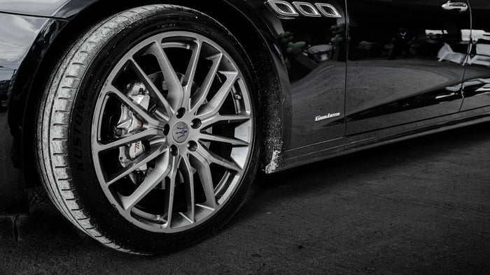 Rueda de un auto negro con llanta de rayos finos