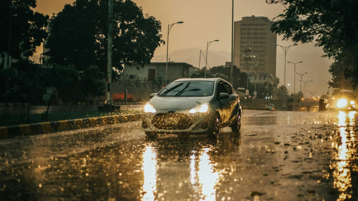 Auto circulando por una calle con lluvia